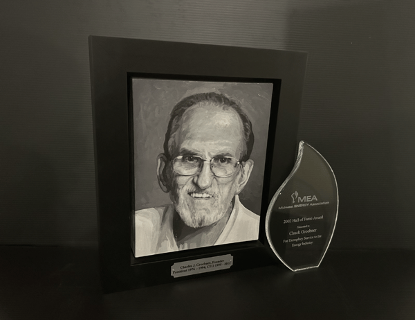 Painting of Charles J Groebner, Founder (President 1976 - 1994, CEO 1905 - 2012) next to 2002 Hall of Fame Midwest ENERGY Association award. 