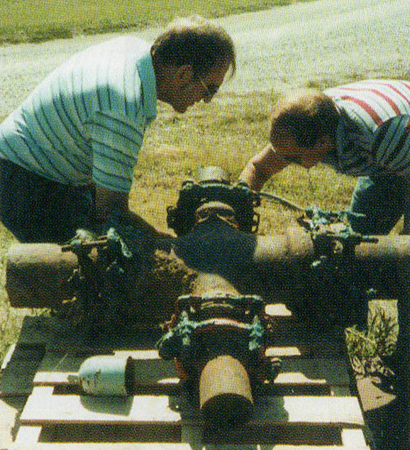 Two men working on a pipe cross-section